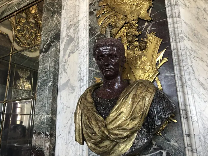 A porphyry bust of a Roman emperor, draped in gilt bronze — Versailles.