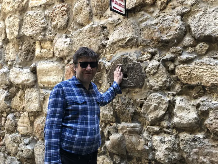 A hand on old stone along the Via Dolorosa, Jerusalem.